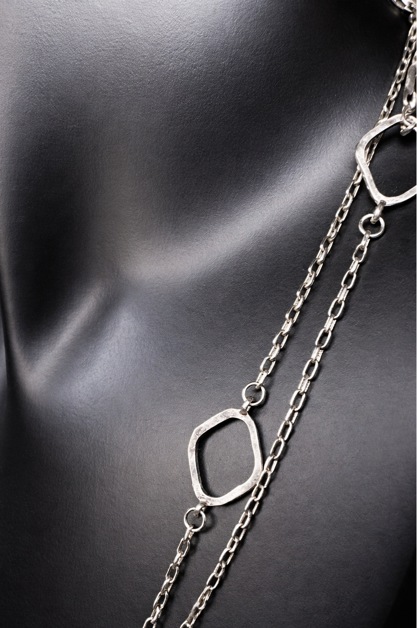 This long sterling silver necklace is designed with intermittent geometric links along the length of the chain. Two of those large links feature a small diamond for a touch of flash in the light. At 34 inches, this can be wrapped twice for a layered look, or it can be worn long. Made by Silpada.