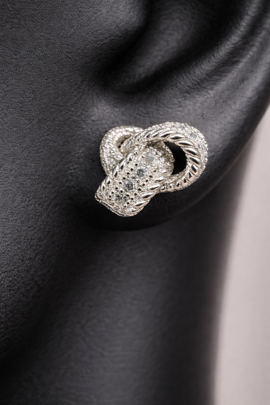 Sterling silver and diamond earrings. Perfect for a special event or just a night out. The diamonds are set along the knotted ribbon design, ready to catch just the right light for a little flash.