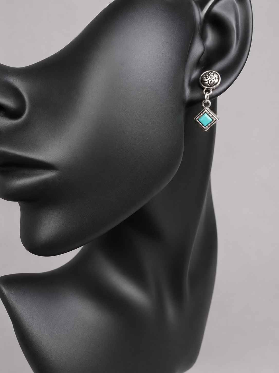 Here are handcrafted sterling silver dangle earrings inspired by native design aesthetics, featuring turquoise accents that swing with natural grace. The intricate silverwork combines traditional artistry with contemporary style, making these earrings a versatile statement piece.