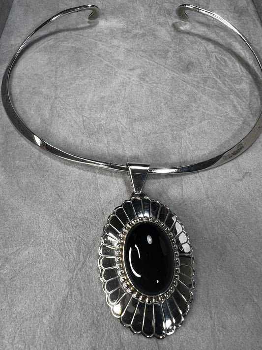 This slide pendant necklace features a large onyx and sterling pendant front and center with a sterling collar. From native American silversmith L. James.