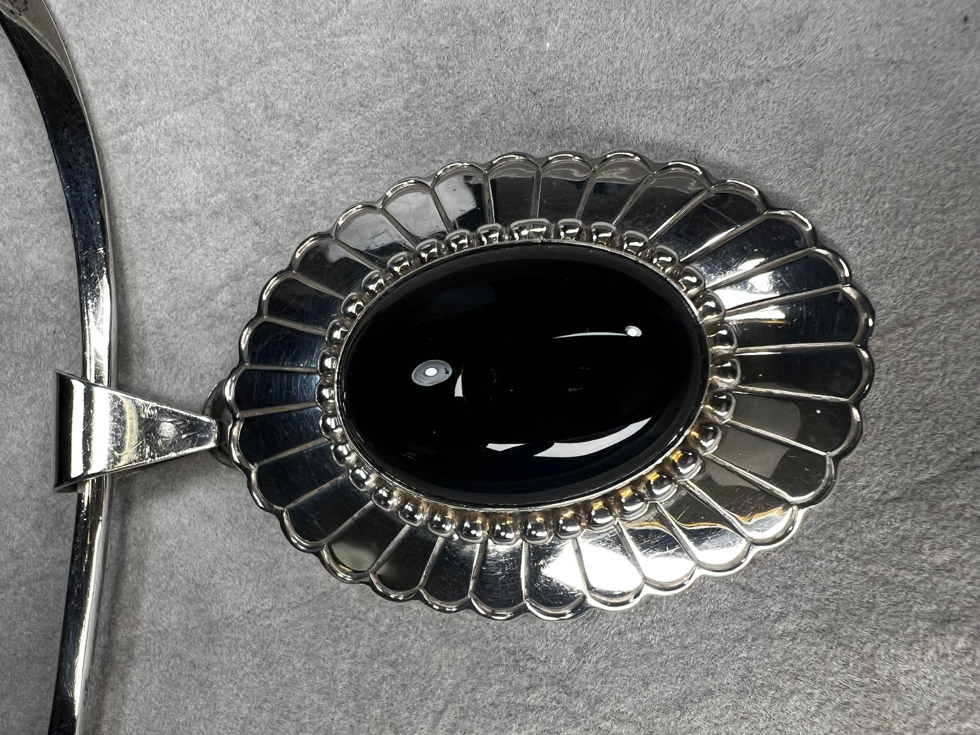 This slide pendant necklace features a large onyx and sterling pendant front and center with a sterling collar. From native American silversmith L. James.