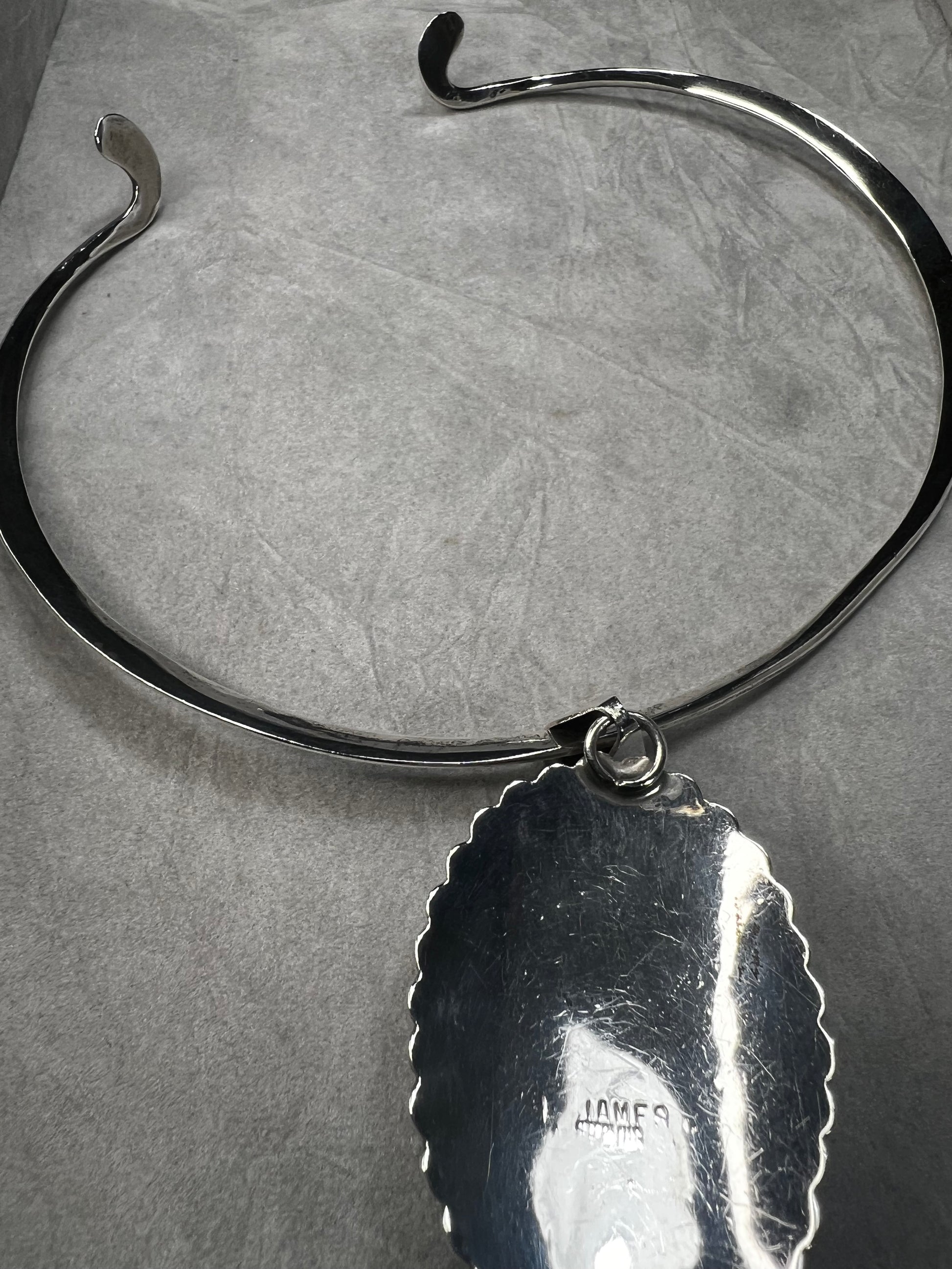 This slide pendant necklace features a large onyx and sterling pendant front and center with a sterling collar. From native American silversmith L. James.