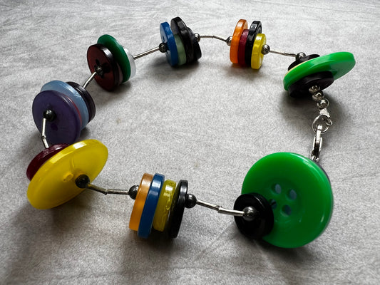 Made with sterling silver beads & clasp, this bracelet features colorful buttons for something different and fun.