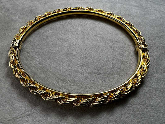 Crafted from sterling silver with a gold overlay, this rope chain bangle bracelet offers both style and comfort. Its beautiful design is complemented by a smooth inner plate for a comfortable fit.