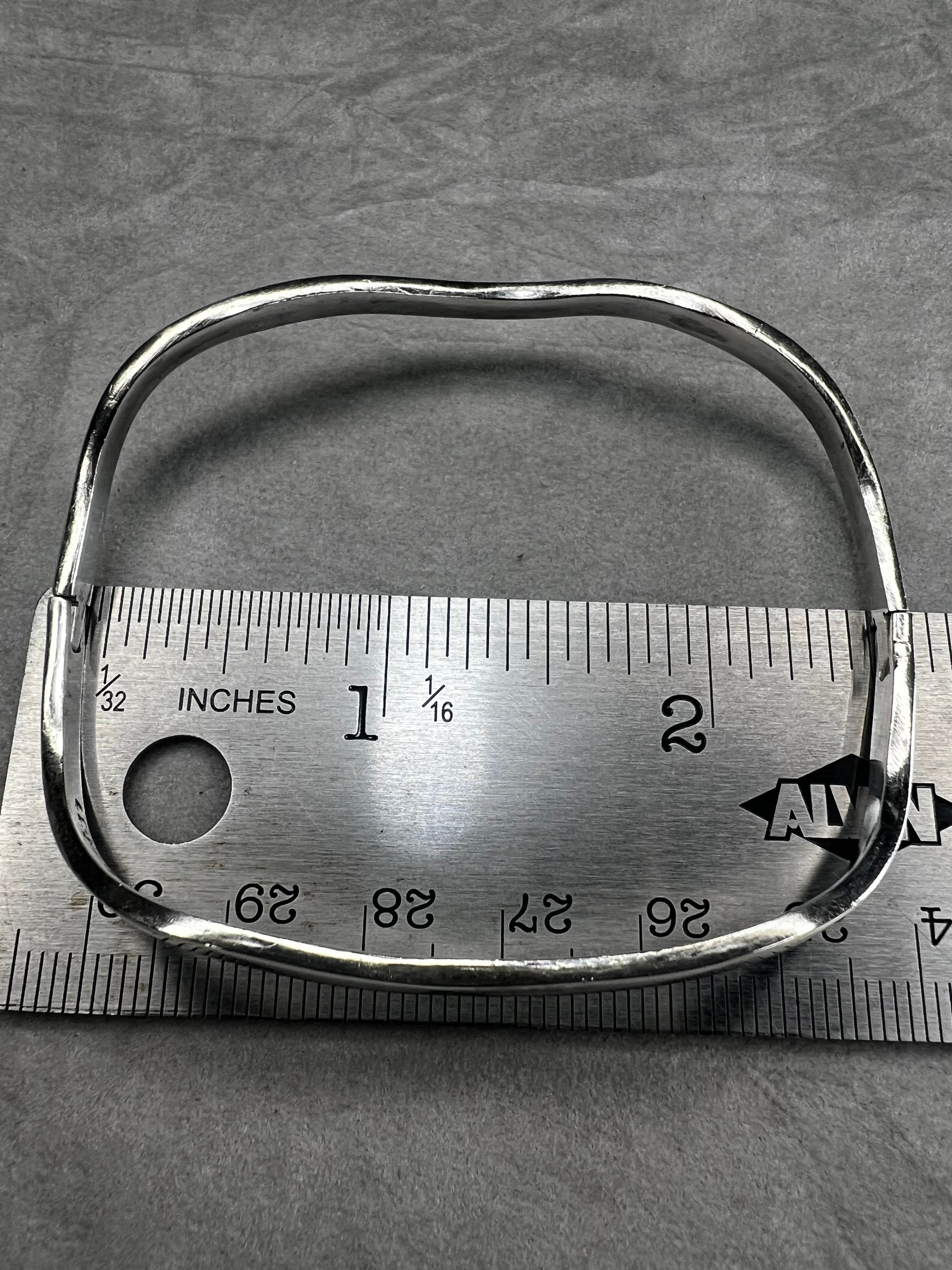 This vintage Taxco sterling silver bracelet features a distinctive wavy design and is marked TM-37, showcasing authentic craftsmanship from Mexico. Its timeless style makes it a versatile accessory for everyday wear or special occasions.