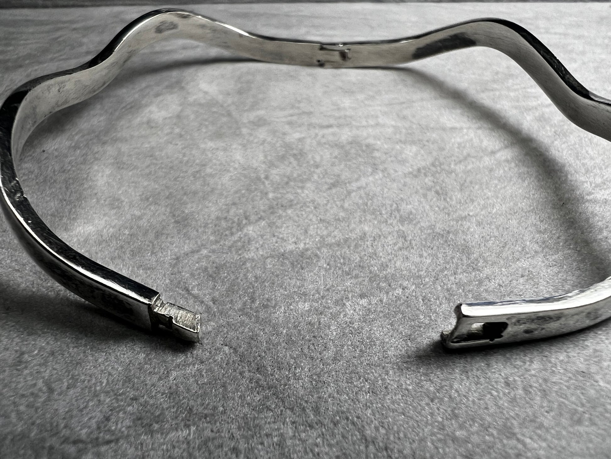 This vintage Taxco sterling silver bracelet features a distinctive wavy design and is marked TM-37, showcasing authentic craftsmanship from Mexico. Its timeless style makes it a versatile accessory for everyday wear or special occasions.