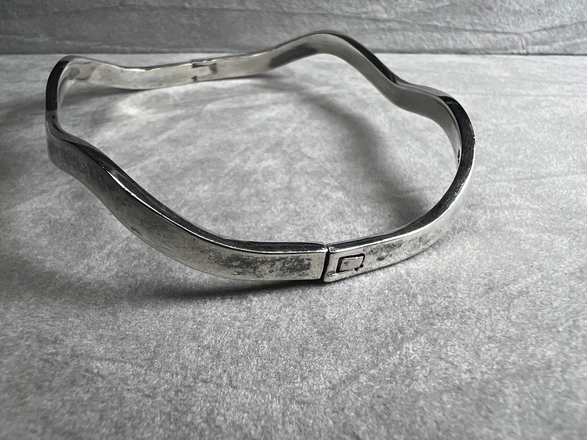 This vintage Taxco sterling silver bracelet features a distinctive wavy design and is marked TM-37, showcasing authentic craftsmanship from Mexico. Its timeless style makes it a versatile accessory for everyday wear or special occasions.