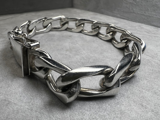 This vintage Cuban link bracelet is a sturdy and stylish accessory crafted from solid sterling silver. Measuring 12mm wide, it features a secure locking clasp designed for durability and everyday wear. Made in Mexico.