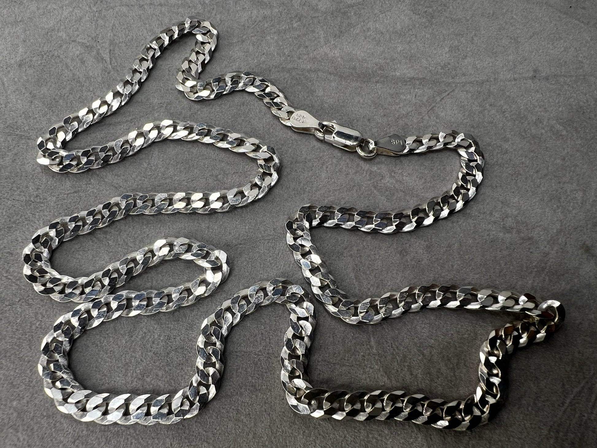 This 24" sterling silver Cuban link chain features a high polish finish that adds a sleek, timeless shine. Its sturdy yet elegant design makes it a versatile accessory, perfect for everyday wear or pairing with your favorite pendant.
