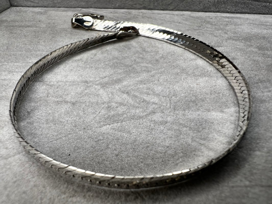 This sterling silver bracelet features a classic herringbone link design, offering a sleek and sophisticated look. It's an ideal accessory for both everyday wear and special occasions.