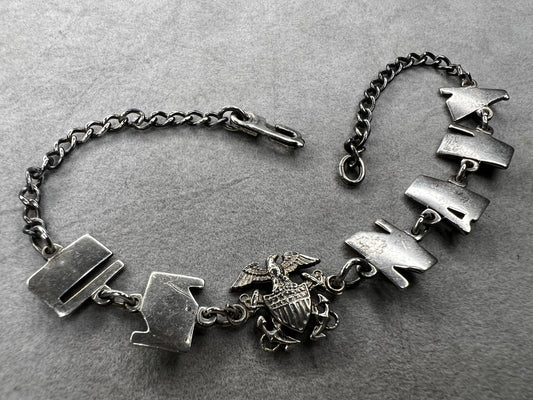 This sterling silver "Forget Me Not" bracelet from the World War II era carries a heartfelt story. Given by a U.S. Navy sailor to a loved one before deployment, it served as a meaningful reminder of their bond during difficult times apart.