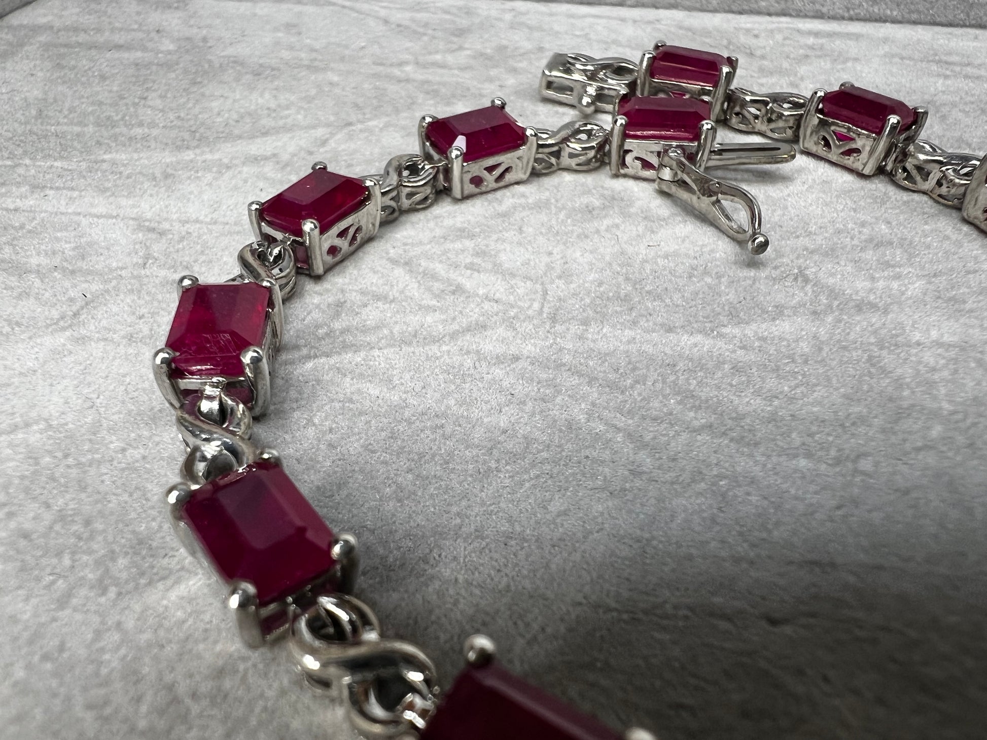 This bracelet is crafted from sterling silver and set with stunning lab-created rubies. It's a piece that's sure to enhance any outfit.
