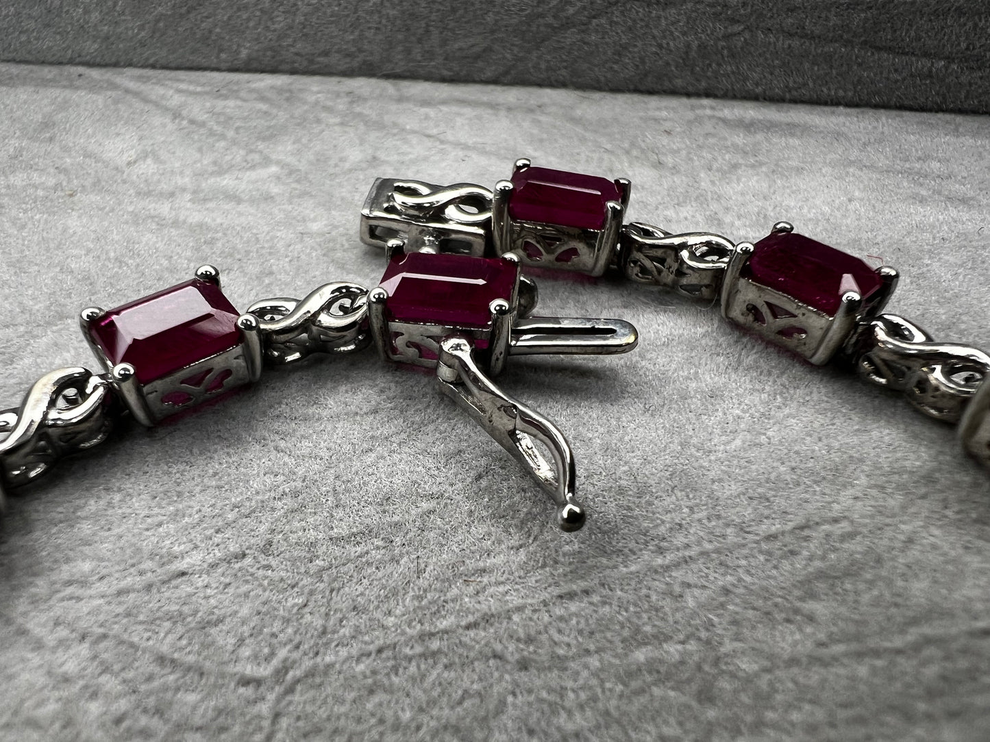This bracelet is crafted from sterling silver and set with stunning lab-created rubies. It's a piece that's sure to enhance any outfit.