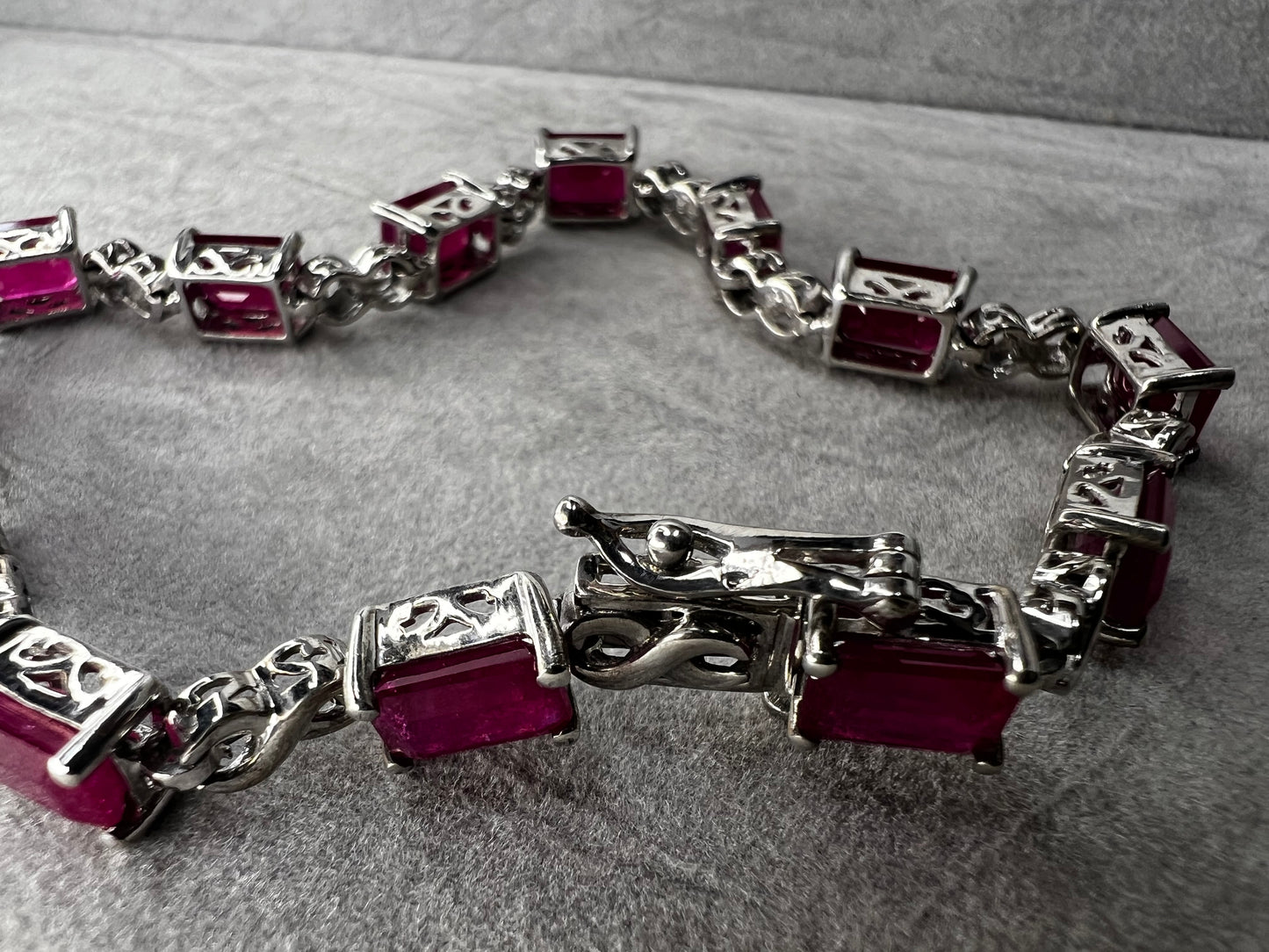 This bracelet is crafted from sterling silver and set with stunning lab-created rubies. It's a piece that's sure to enhance any outfit.