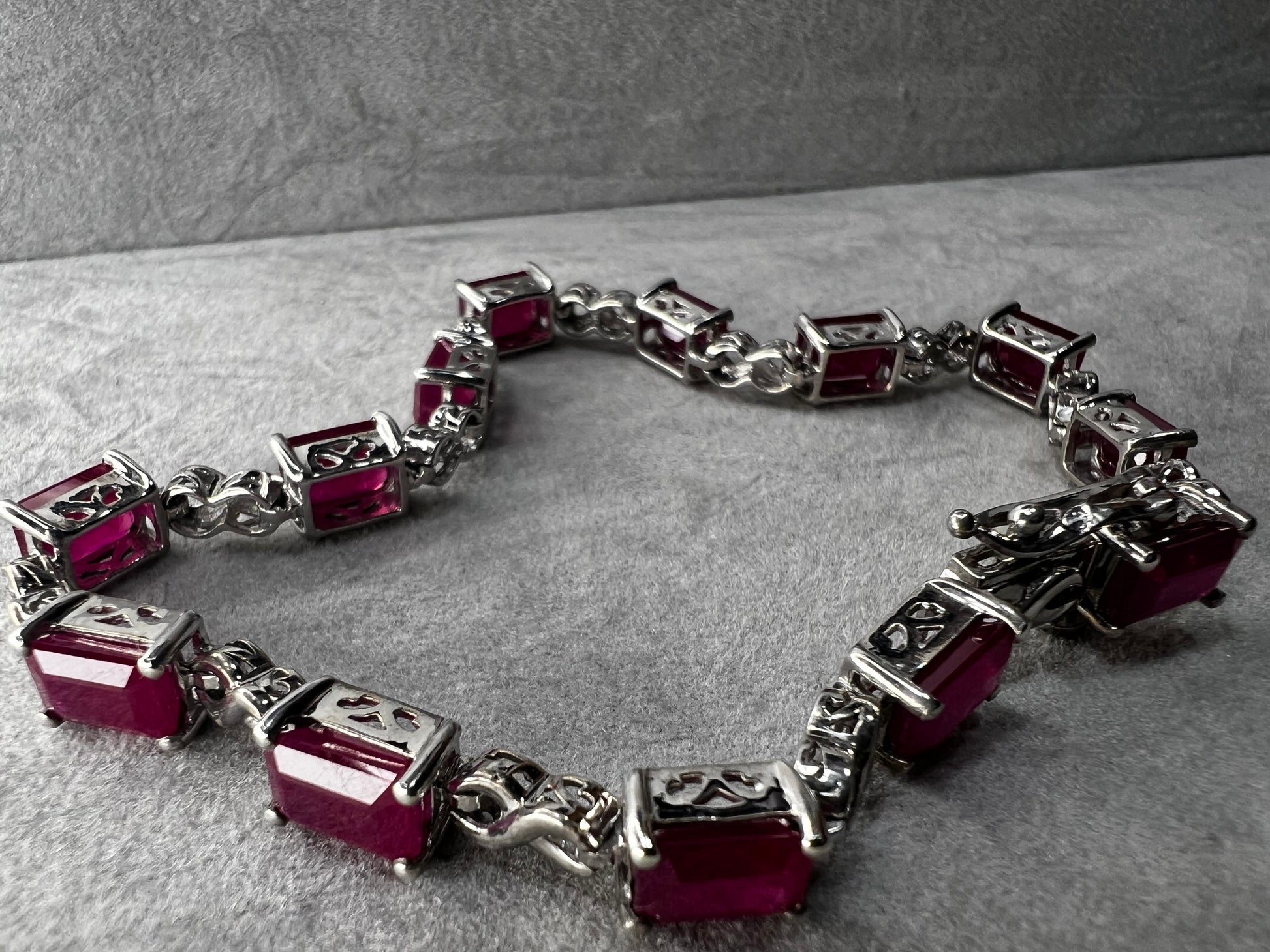 This bracelet is crafted from sterling silver and set with stunning lab-created rubies. It's a piece that's sure to enhance any outfit.