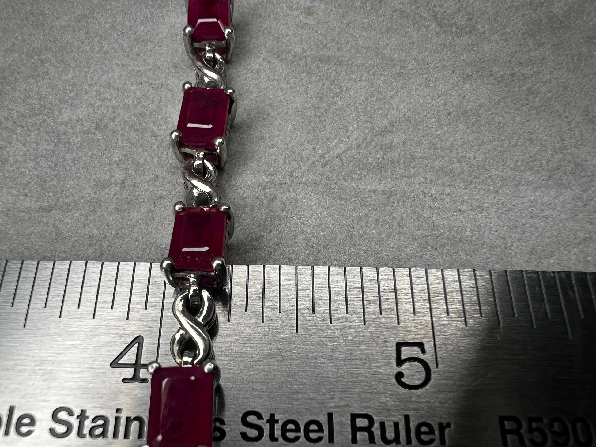 This bracelet is crafted from sterling silver and set with stunning lab-created rubies. It's a piece that's sure to enhance any outfit.