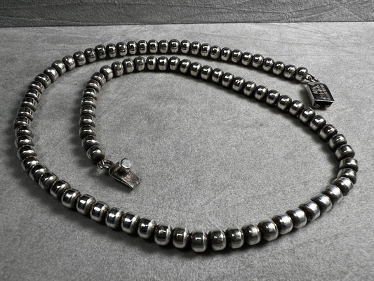 This vintage necklace from Taxco features a sterling silver chain accented with authentic Navajo pearl beads, showcasing traditional craftsmanship. Its timeless design makes it a distinguished addition to any Taxco collection, offering both cultural significance and enduring style.