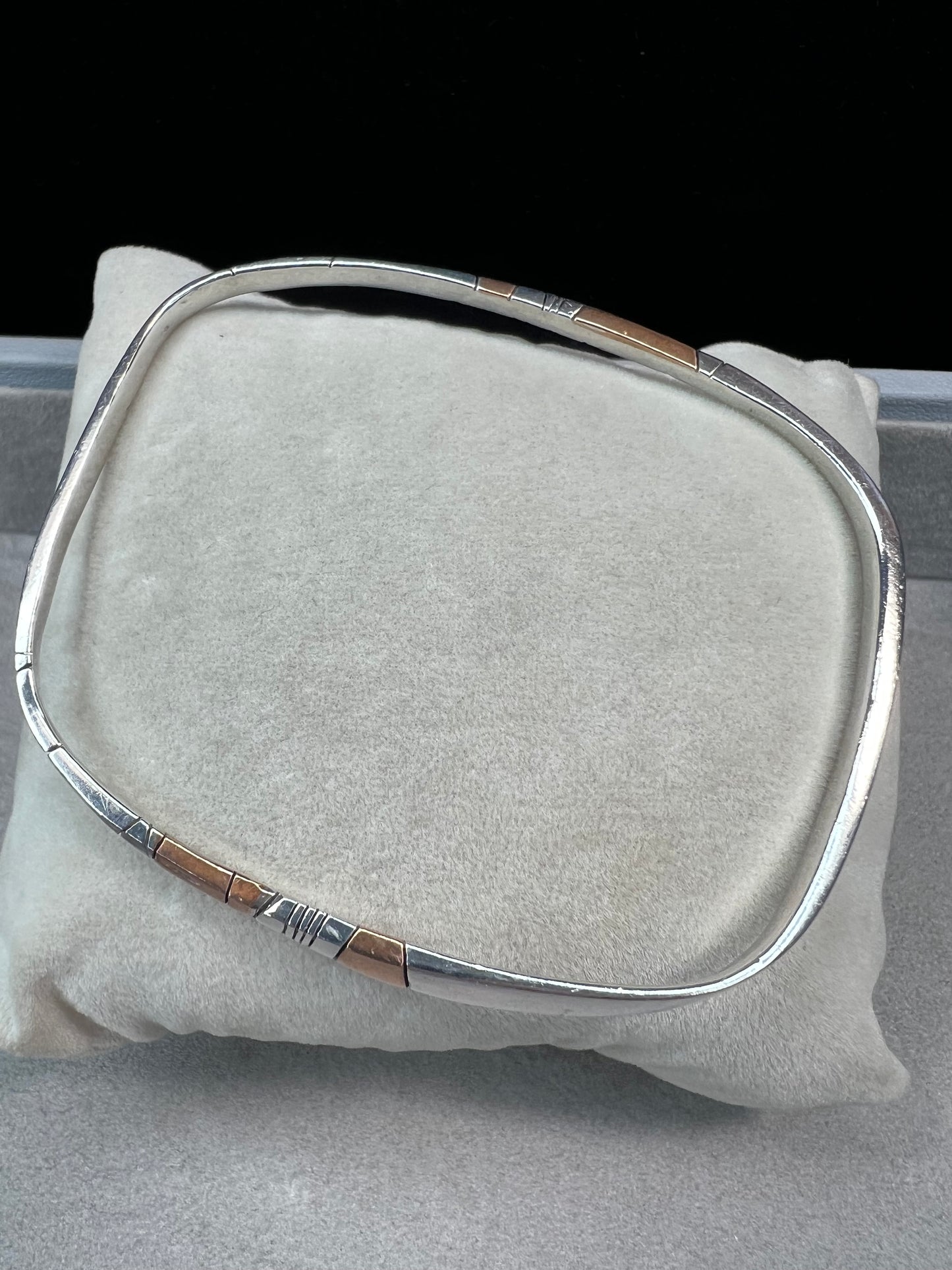 Here is an elegant vintage sterling silver bracelet featuring inlaid copper accents and hand-etched detailing. The distinctive rectangular design creates a modern yet timeless aesthetic, making this piece a standout addition to any jewelry collection.