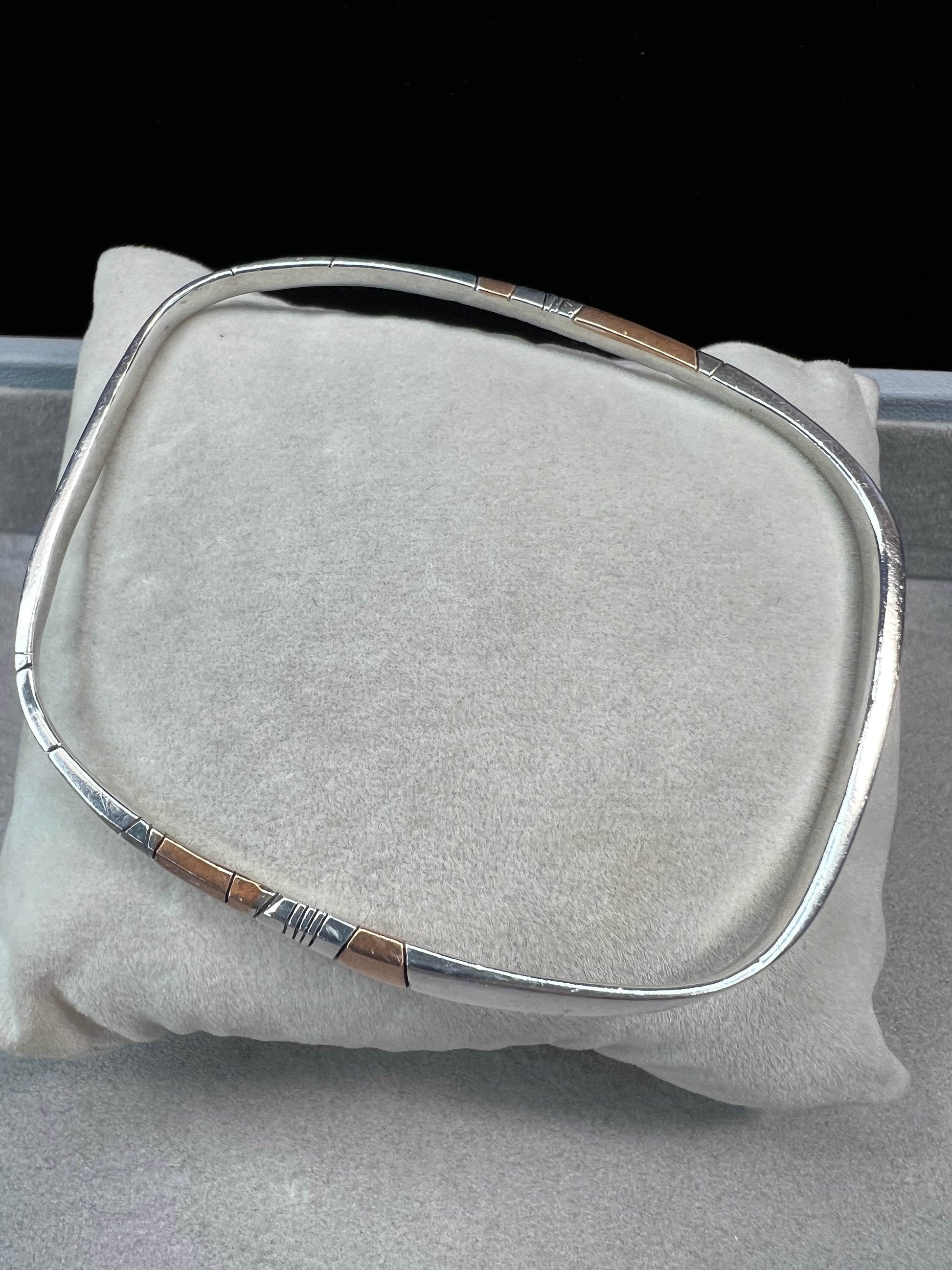 Here is an elegant vintage sterling silver bracelet featuring inlaid copper accents and hand-etched detailing. The distinctive rectangular design creates a modern yet timeless aesthetic, making this piece a standout addition to any jewelry collection.