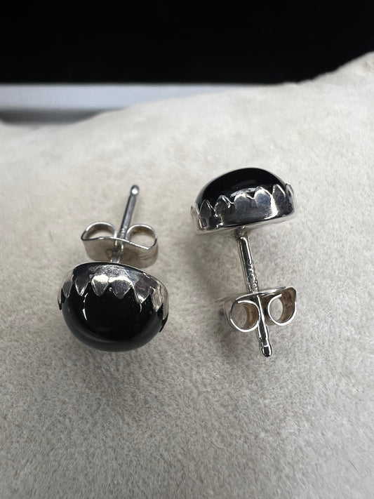 These sterling silver stud earrings feature sleek jet stones, offering a refined and timeless accessory. Their modest size ensures subtle elegance, perfect for adding a sophisticated touch to any outfit without overpowering your look.