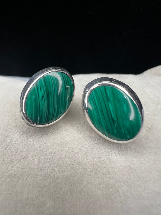 These vintage Mexican earrings showcase genuine malachite stones expertly set in sterling silver. Each piece is hallmarked, reflecting authentic craftsmanship and quality.