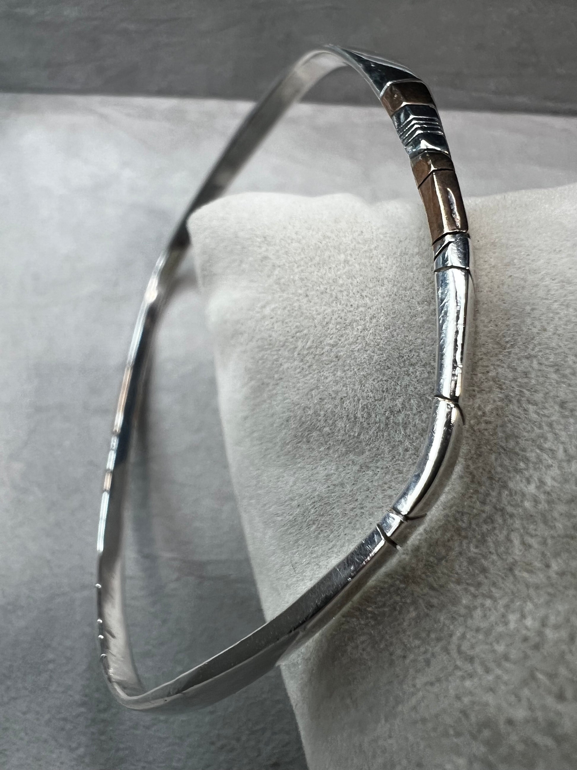 Here is an elegant vintage sterling silver bracelet featuring inlaid copper accents and hand-etched detailing. The distinctive rectangular design creates a modern yet timeless aesthetic, making this piece a standout addition to any jewelry collection.