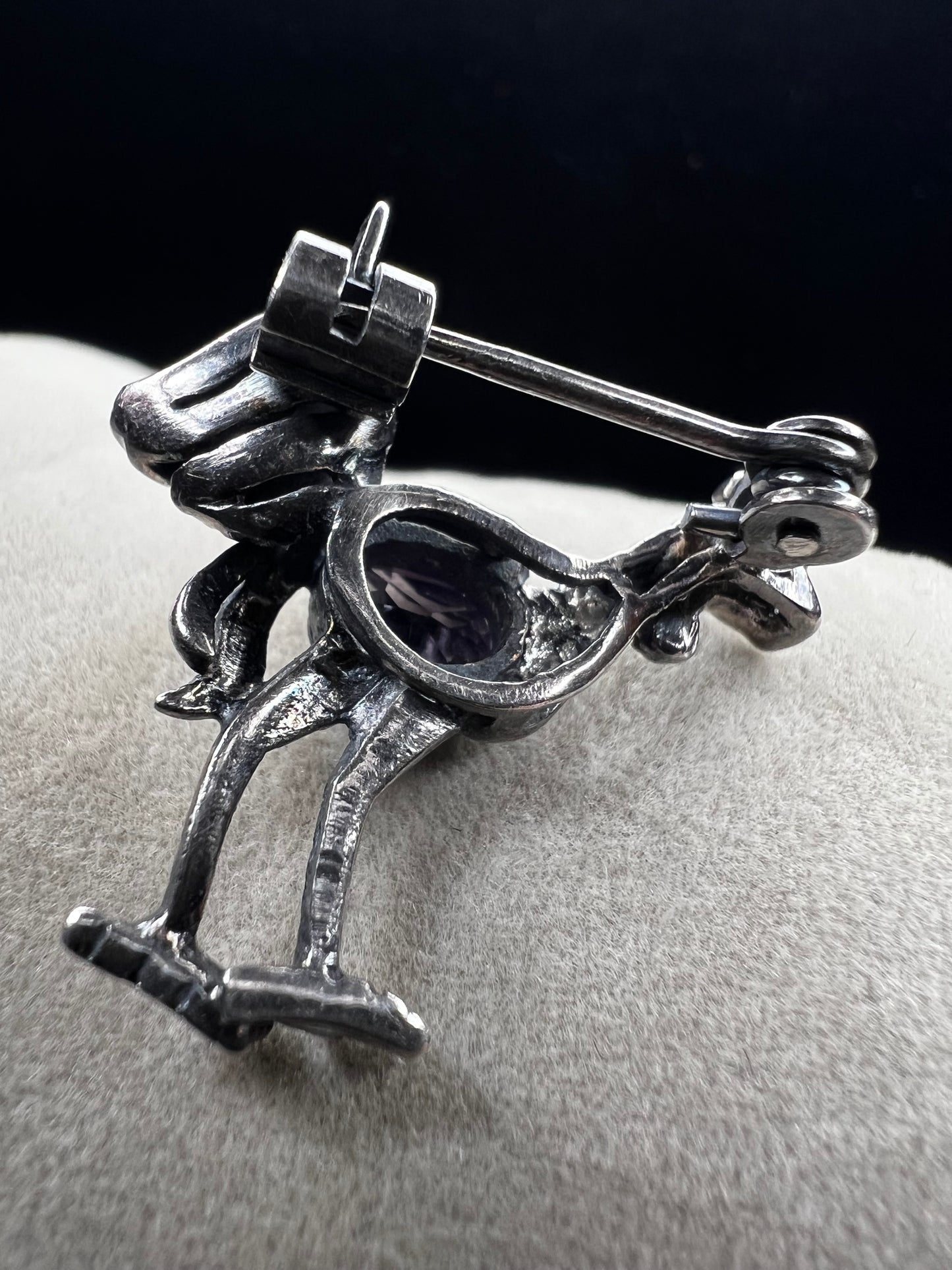 This is a striking mid-century rooster brooch that captures vintage elegance and whimsy. Handcrafted in sterling silver, this statement piece features a vibrant amethyst belly, accented with shimmering marcasite details that catch the light. Perfect for adding character to any outfit or displaying as a collectible treasure.
