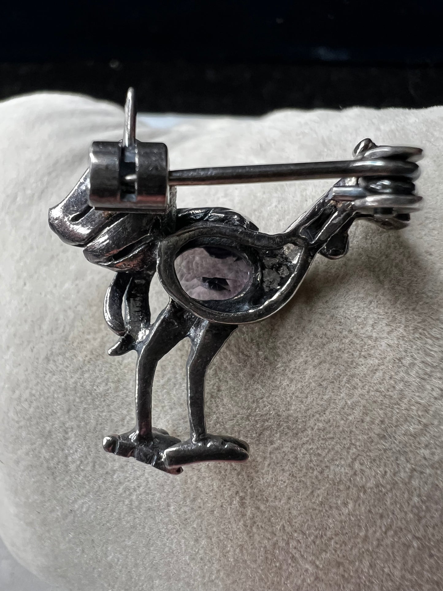 This is a striking mid-century rooster brooch that captures vintage elegance and whimsy. Handcrafted in sterling silver, this statement piece features a vibrant amethyst belly, accented with shimmering marcasite details that catch the light. Perfect for adding character to any outfit or displaying as a collectible treasure.