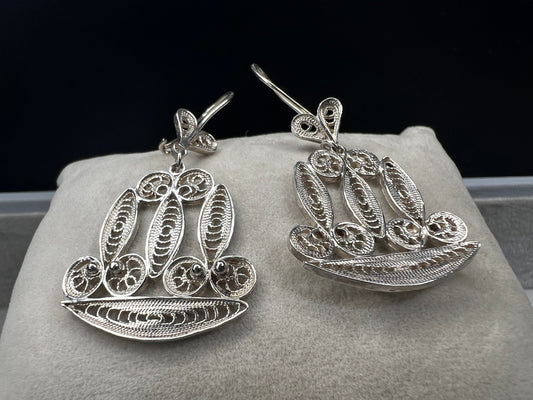 These sterling silver filigree earrings showcase intricate craftsmanship, offering a distinctive and elegant accessory. Their delicate design adds a refined touch to any outfit, making them ideal for those seeking subtle sophistication with a unique flair.