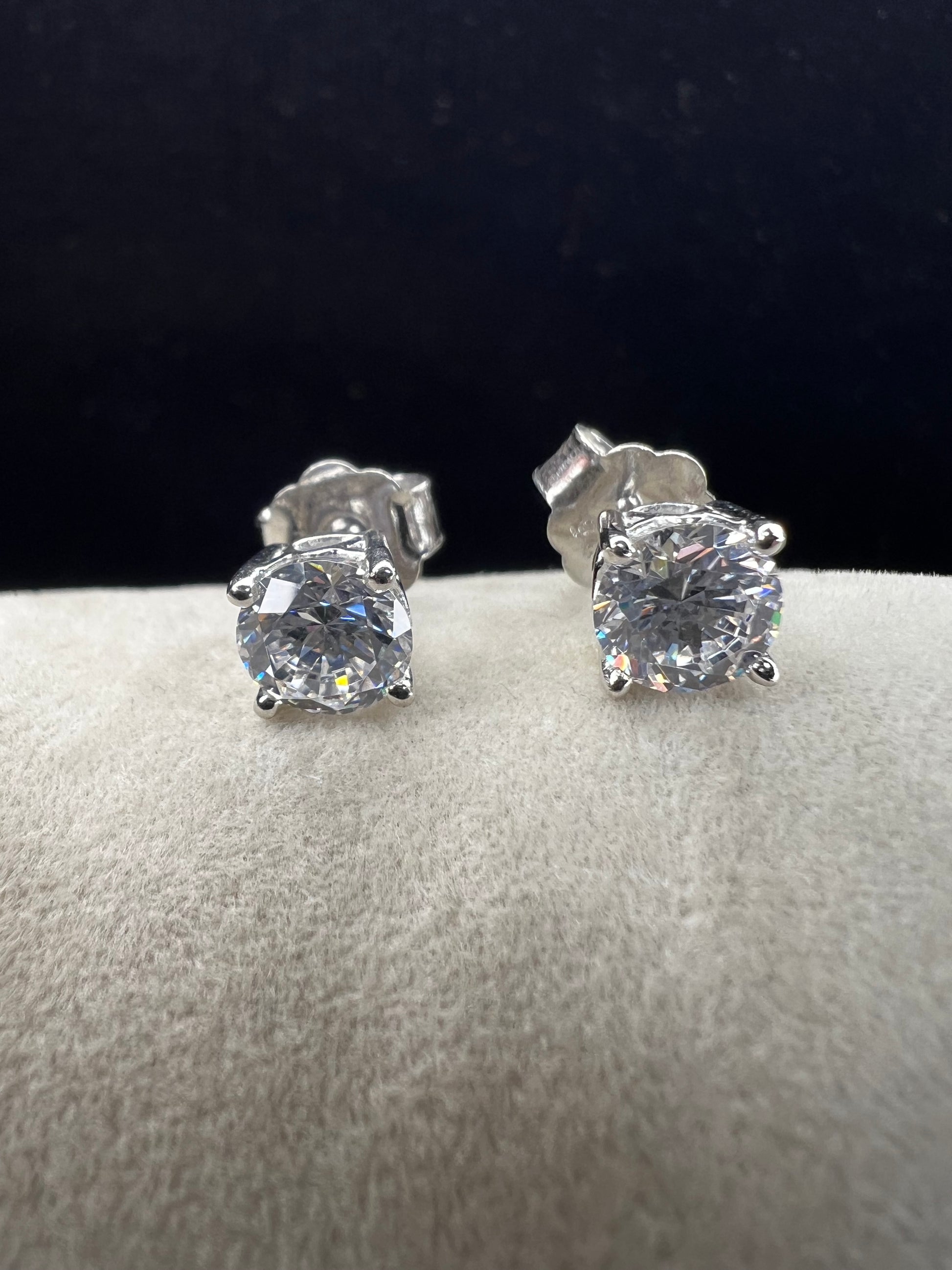 These sterling silver and CZ earrings combine timeless elegance with modern sparkle. Each piece features a generous 6 mm cubic zirconia stone set in premium sterling silver, delivering brilliant shine at a fraction of the cost of diamonds. Perfect for everyday wear or special occasions, these earrings offer versatile style that complements any wardrobe.