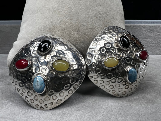 These vintage Taxco sterling silver clip-on earrings feature authentic hallmarks and vibrant natural stone cabochons. Expertly crafted, they combine timeless Mexican silver artistry with bold, eye-catching colors, making them a distinguished accessory for collectors and connoisseurs of fine vintage jewelry.