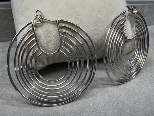 These sterling silver hoop earrings feature seven intricately crafted loops on each hoop, combining elegance with a distinctive design.