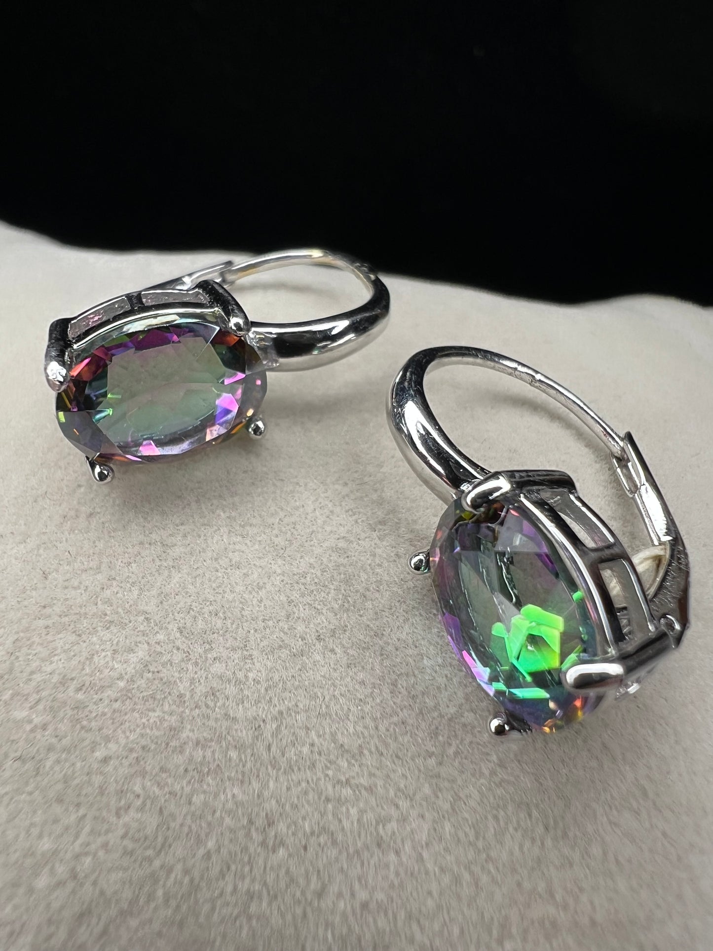 Elevate your everyday elegance with these stunning sterling silver mystic topaz earrings. Each piece showcases a radiant lab-created mystic topaz stone measuring 10 mm x 8 mm, displaying mesmerizing rainbow hues that catch the light beautifully. Crafted from genuine sterling silver, these earrings offer a perfect balance of sophistication and eye-catching sparkle.