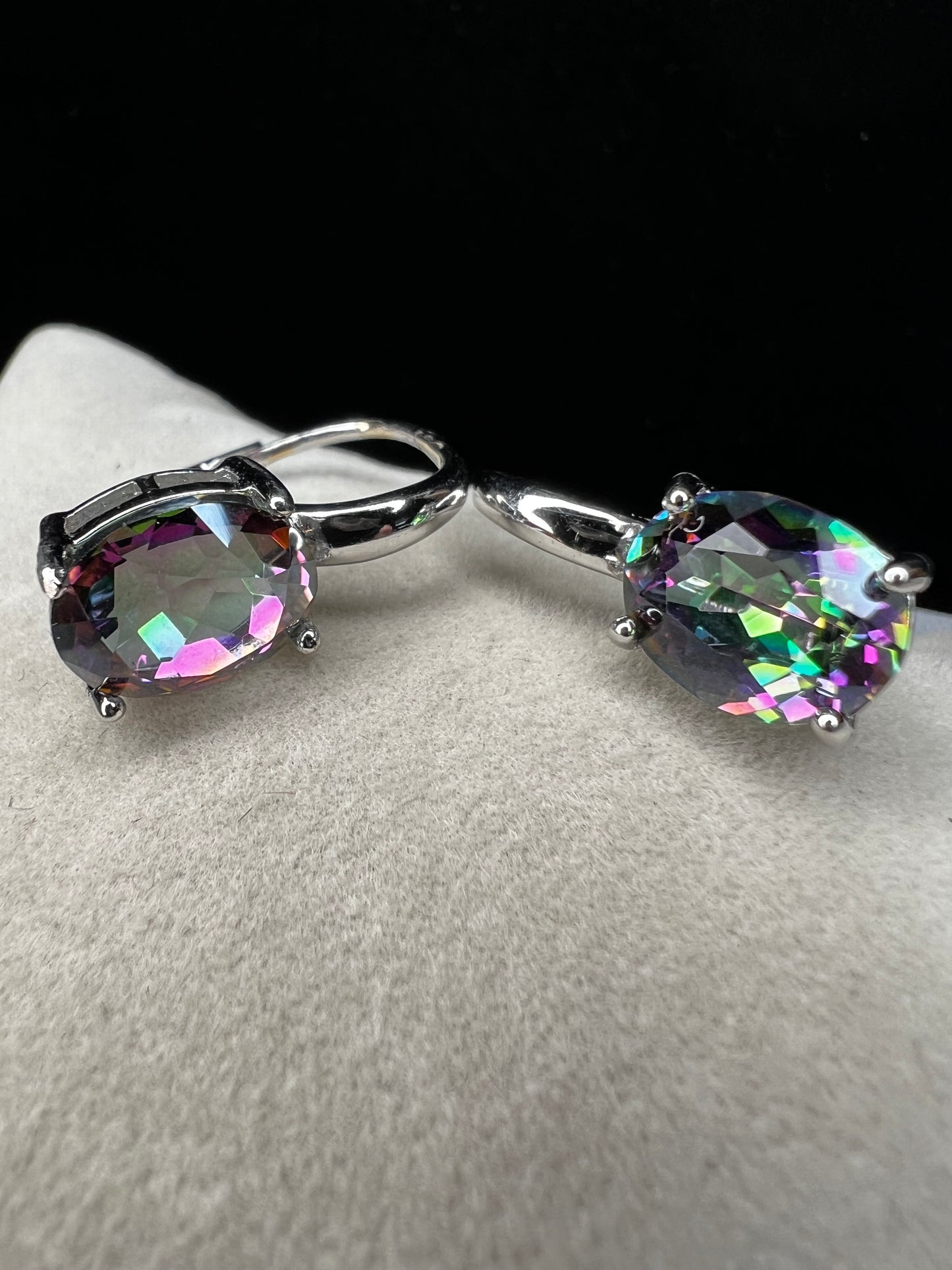 Elevate your everyday elegance with these stunning sterling silver mystic topaz earrings. Each piece showcases a radiant lab-created mystic topaz stone measuring 10 mm x 8 mm, displaying mesmerizing rainbow hues that catch the light beautifully. Crafted from genuine sterling silver, these earrings offer a perfect balance of sophistication and eye-catching sparkle.