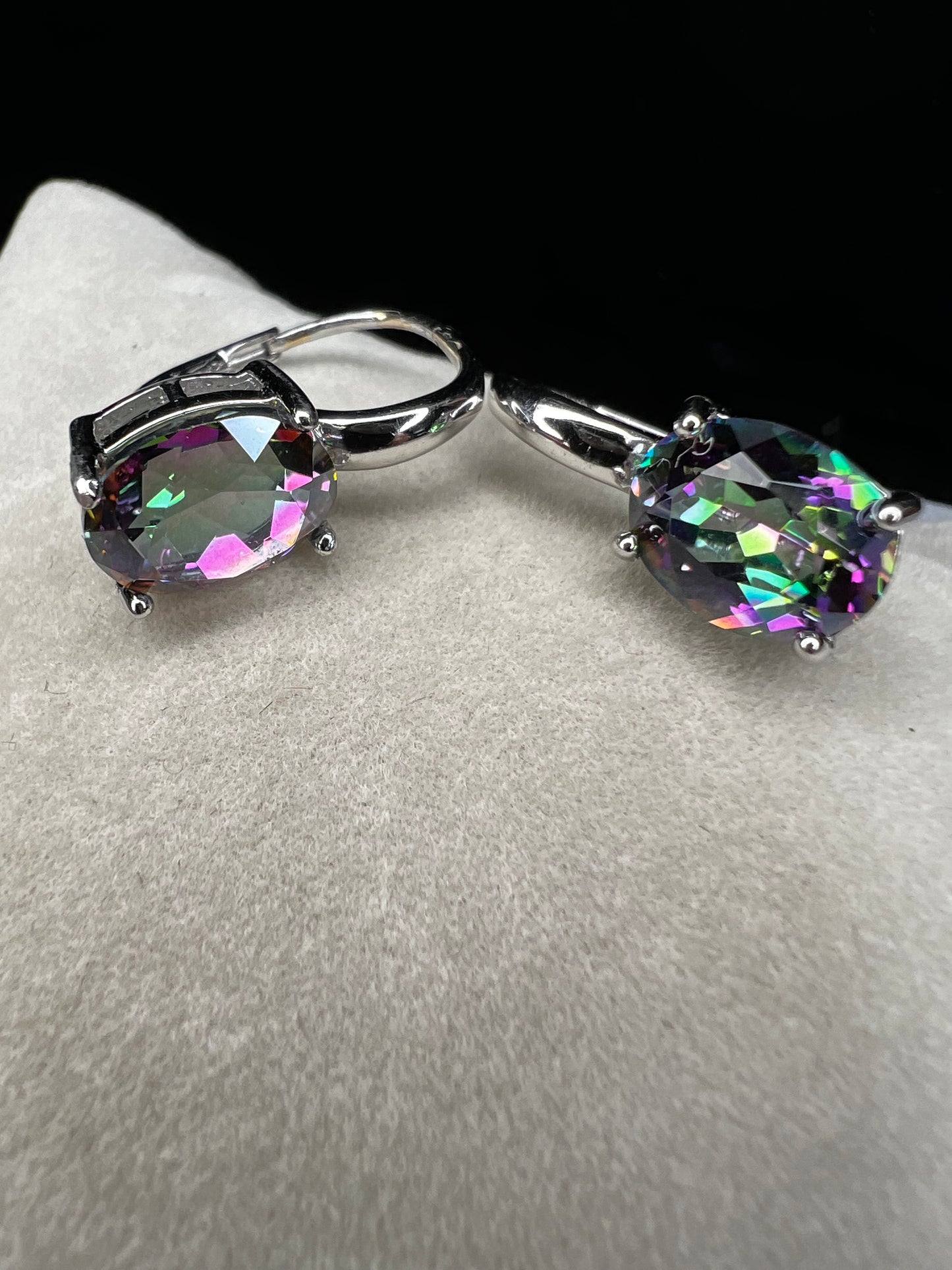 Elevate your everyday elegance with these stunning sterling silver mystic topaz earrings. Each piece showcases a radiant lab-created mystic topaz stone measuring 10 mm x 8 mm, displaying mesmerizing rainbow hues that catch the light beautifully. Crafted from genuine sterling silver, these earrings offer a perfect balance of sophistication and eye-catching sparkle.