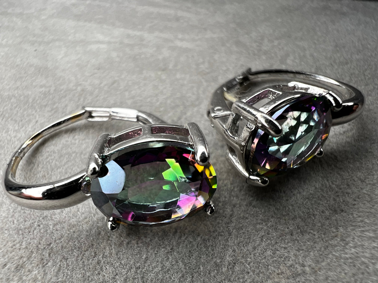 Elevate your everyday elegance with these stunning sterling silver mystic topaz earrings. Each piece showcases a radiant lab-created mystic topaz stone measuring 10 mm x 8 mm, displaying mesmerizing rainbow hues that catch the light beautifully. Crafted from genuine sterling silver, these earrings offer a perfect balance of sophistication and eye-catching sparkle.