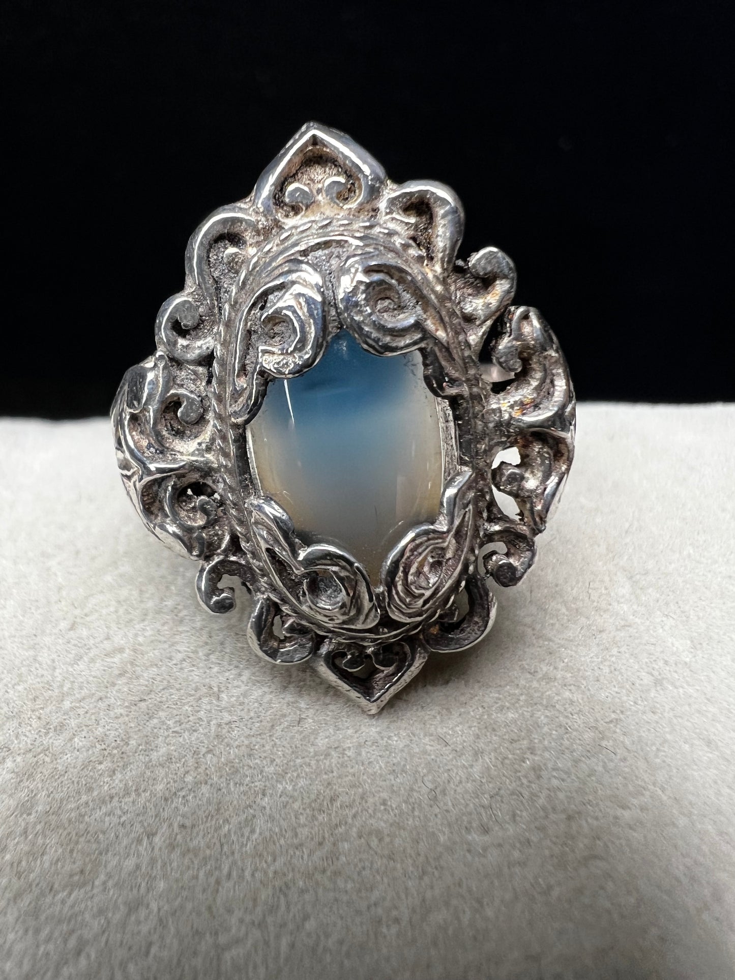 Discover timeless elegance with this vintage sterling silver ring, showcasing an intricate filigree design that gracefully frames a luminous moonstone. The delicate metalwork and soft, ethereal glow of the moonstone create a sophisticated piece perfect for everyday wear or special occasions.