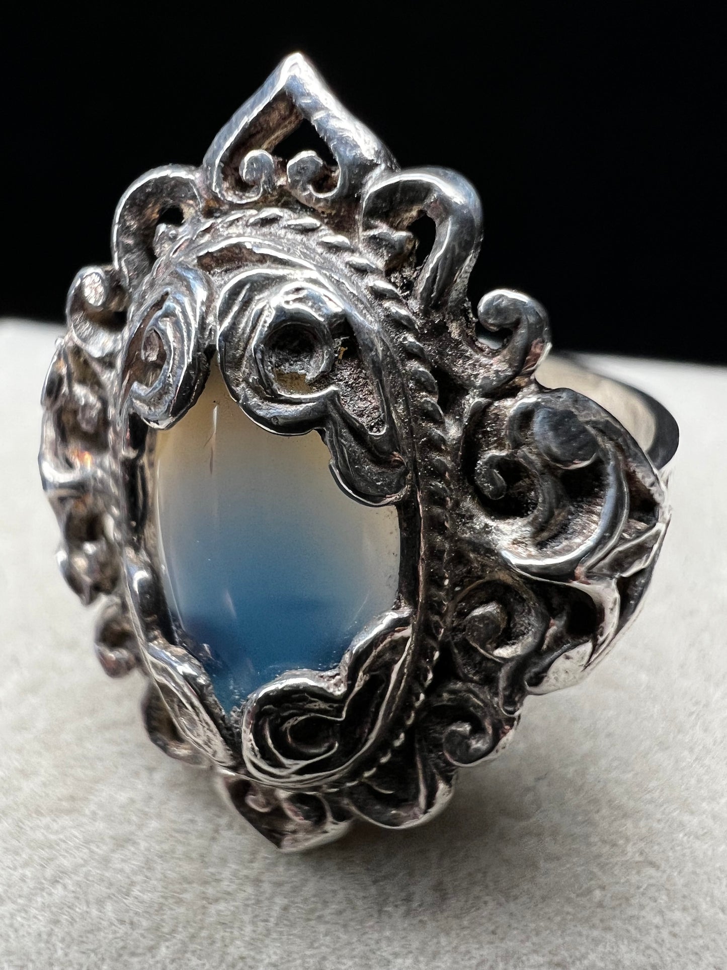 Discover timeless elegance with this vintage sterling silver ring, showcasing an intricate filigree design that gracefully frames a luminous moonstone. The delicate metalwork and soft, ethereal glow of the moonstone create a sophisticated piece perfect for everyday wear or special occasions.