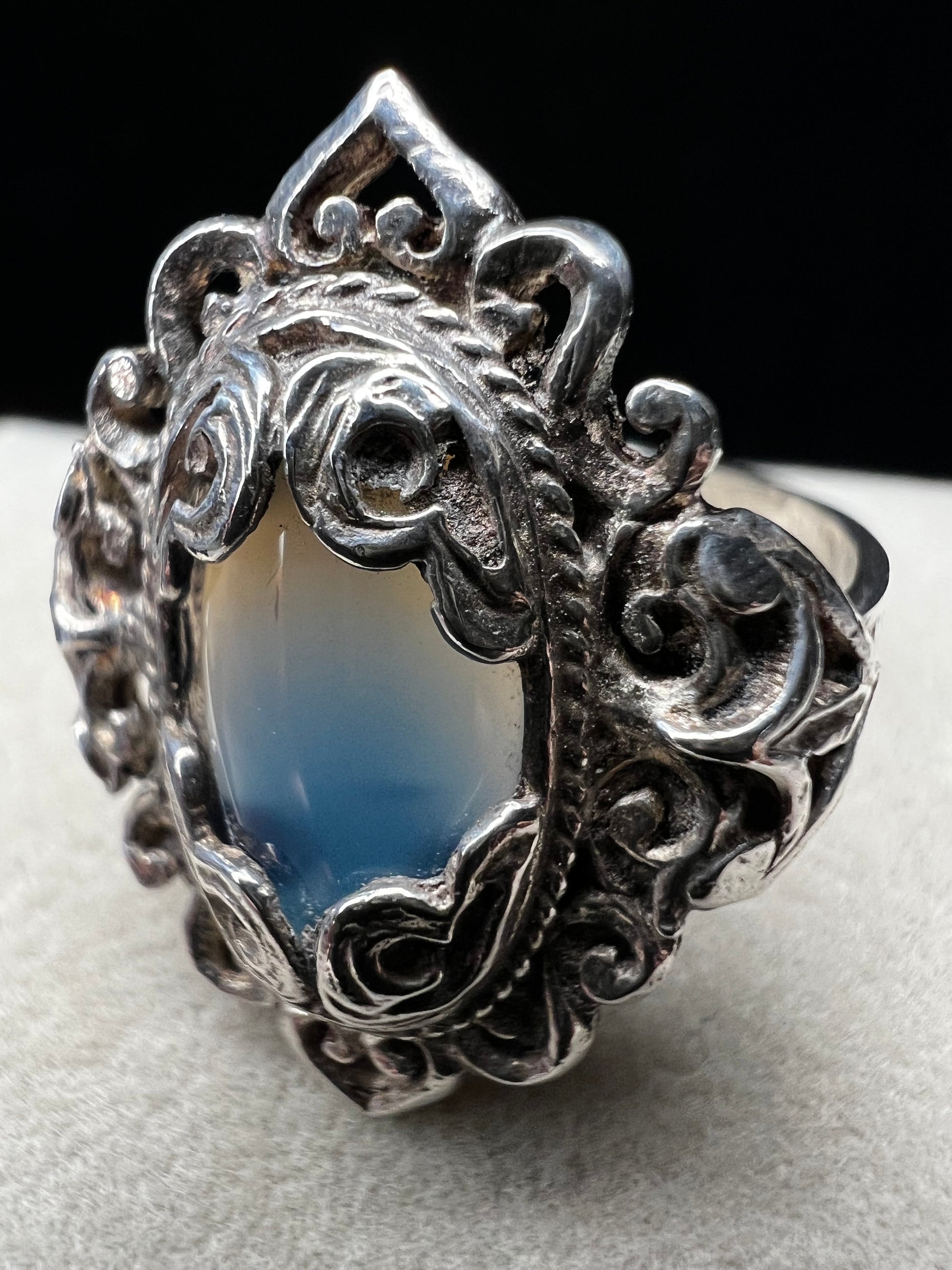 Discover timeless elegance with this vintage sterling silver ring, showcasing an intricate filigree design that gracefully frames a luminous moonstone. The delicate metalwork and soft, ethereal glow of the moonstone create a sophisticated piece perfect for everyday wear or special occasions.