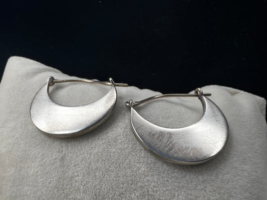 These sterling silver half moon earrings feature a brushed finish on the bottom half, paired with gold overlays on the top hooks. Combining silver and gold tones, they offer a modern, versatile style that complements everyday wear while adding an elegant touch.