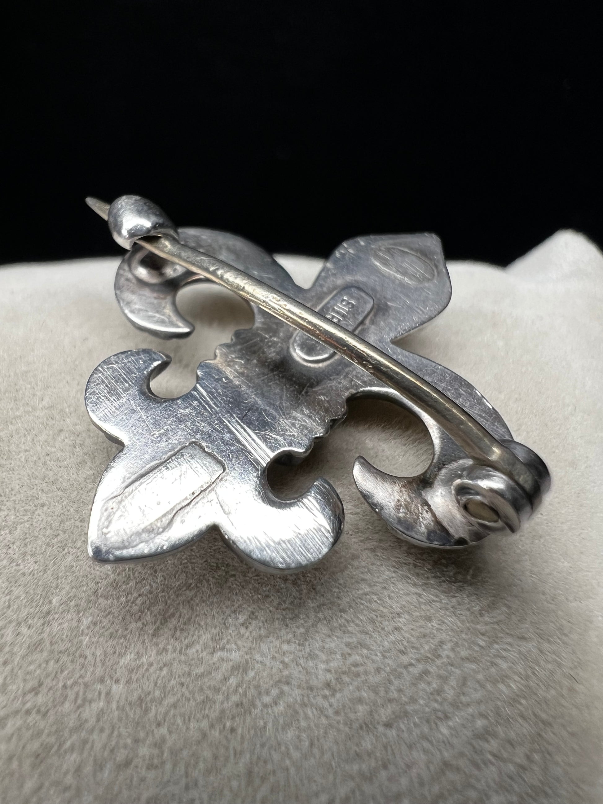 Elevate your vintage jewelry collection with this exquisite sterling silver Fleur De Lis brooch. Crafted with meticulous detail work, this timeless pin showcases the classic French symbol in sterling silver. Perfect for adding sophistication to any outfit or displaying as a treasured collectible.