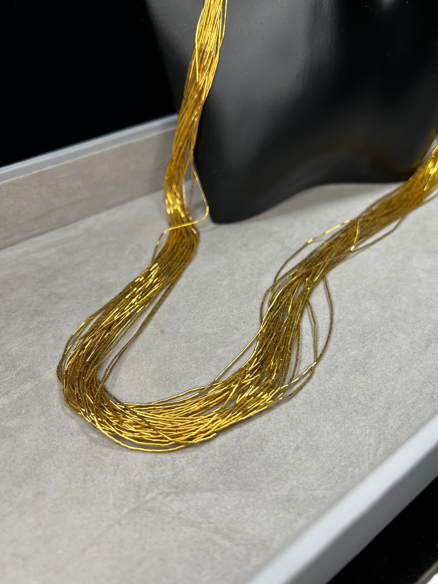 This is a striking gold over sterling silver necklace, featuring the iconic liquid-sterling design. The fluid, sculptural form creates visual movement and dimension, while the gold overlay adds warmth and luxury to the cool brilliance of sterling silver. With substantial length and thickness, this piece commands attention as a standalone statement.