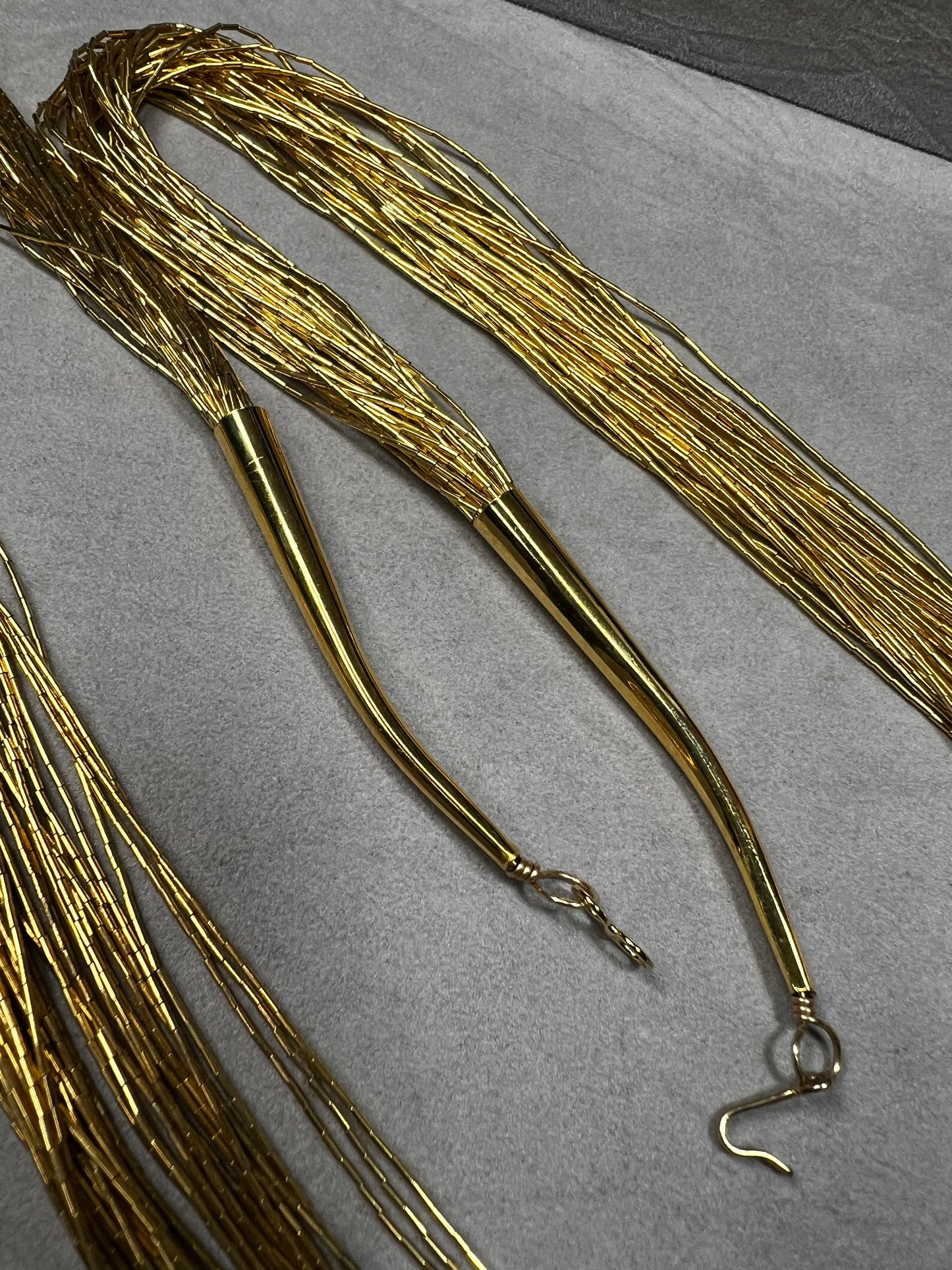This is a striking gold over sterling silver necklace, featuring the iconic liquid-sterling design. The fluid, sculptural form creates visual movement and dimension, while the gold overlay adds warmth and luxury to the cool brilliance of sterling silver. With substantial length and thickness, this piece commands attention as a standalone statement.