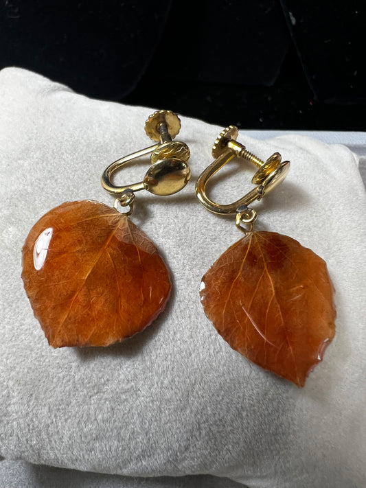These earrings feature a natural leaf preserved in resin, elegantly paired with a gold fill screw back for a secure, non-pierced fit. This design offers a distinctive, nature-inspired accessory that combines organic beauty with expert craftsmanship.