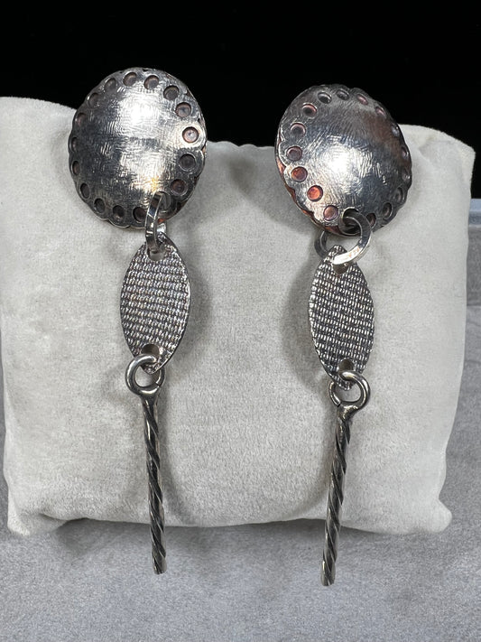 These sterling silver dangle earrings feature a distinctive 3-inch length and are signed by the designer, ensuring authenticity and exclusivity. Their elegant design complements both casual and formal attire.