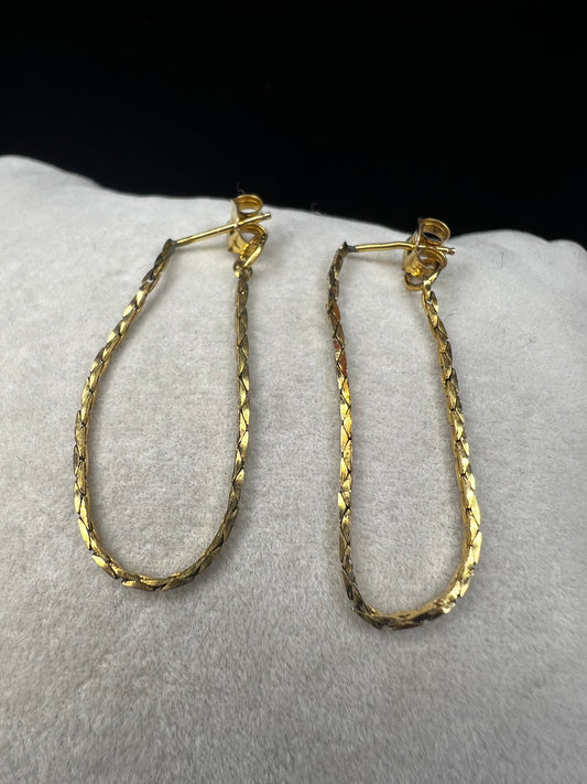 Crafted from 14k gold filled metal, these chain loop earrings feature permanently attached backs for a secure fit. The post passes through the ear, and the back loops around to close, combining elegant design with reliable functionality.