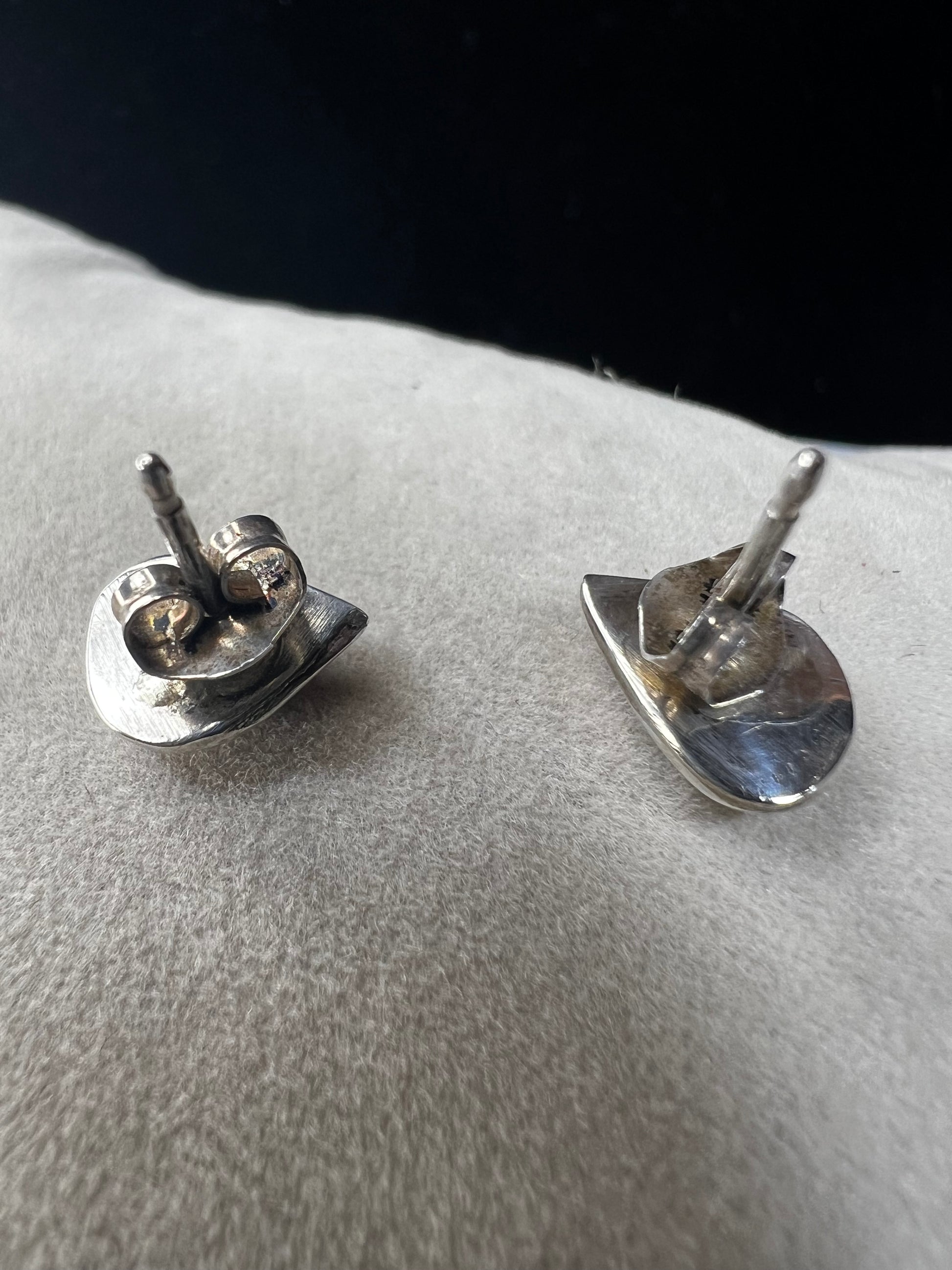 These small vintage sterling silver earrings feature delicate mother of pearl inlays accented with a splash of color. Their classic design adds a vintage-inspired touch that complements both casual and formal ensembles with subtle sophistication.