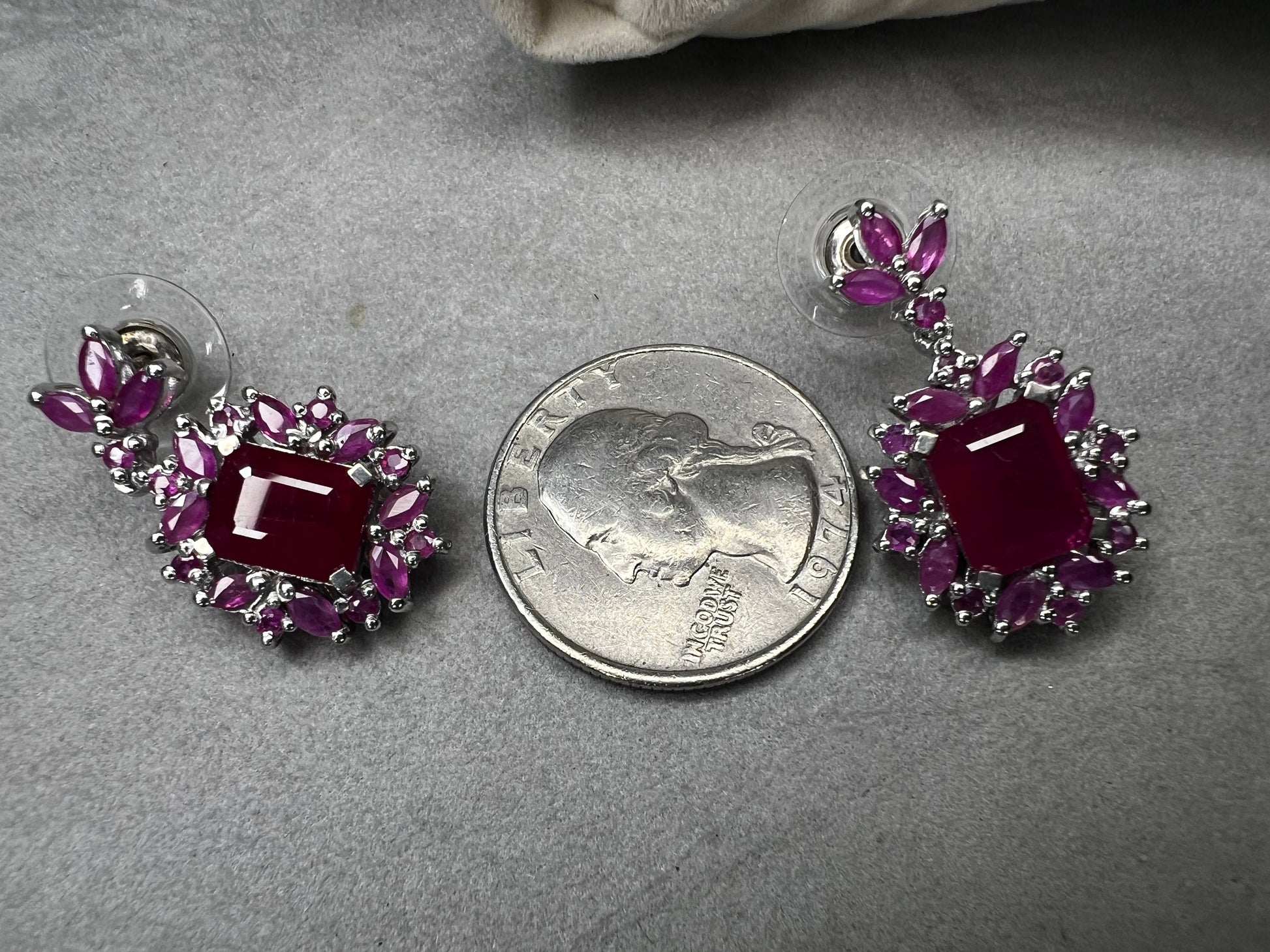 These sterling silver earrings feature a striking large ruby centerpiece, elegantly framed by sparkling topaz stones. Crafted with lab-created gems, they offer a luxurious look at a more accessible price point.