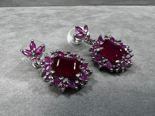 These sterling silver earrings feature a striking large ruby centerpiece, elegantly framed by sparkling topaz stones. Crafted with lab-created gems, they offer a luxurious look at a more accessible price point.