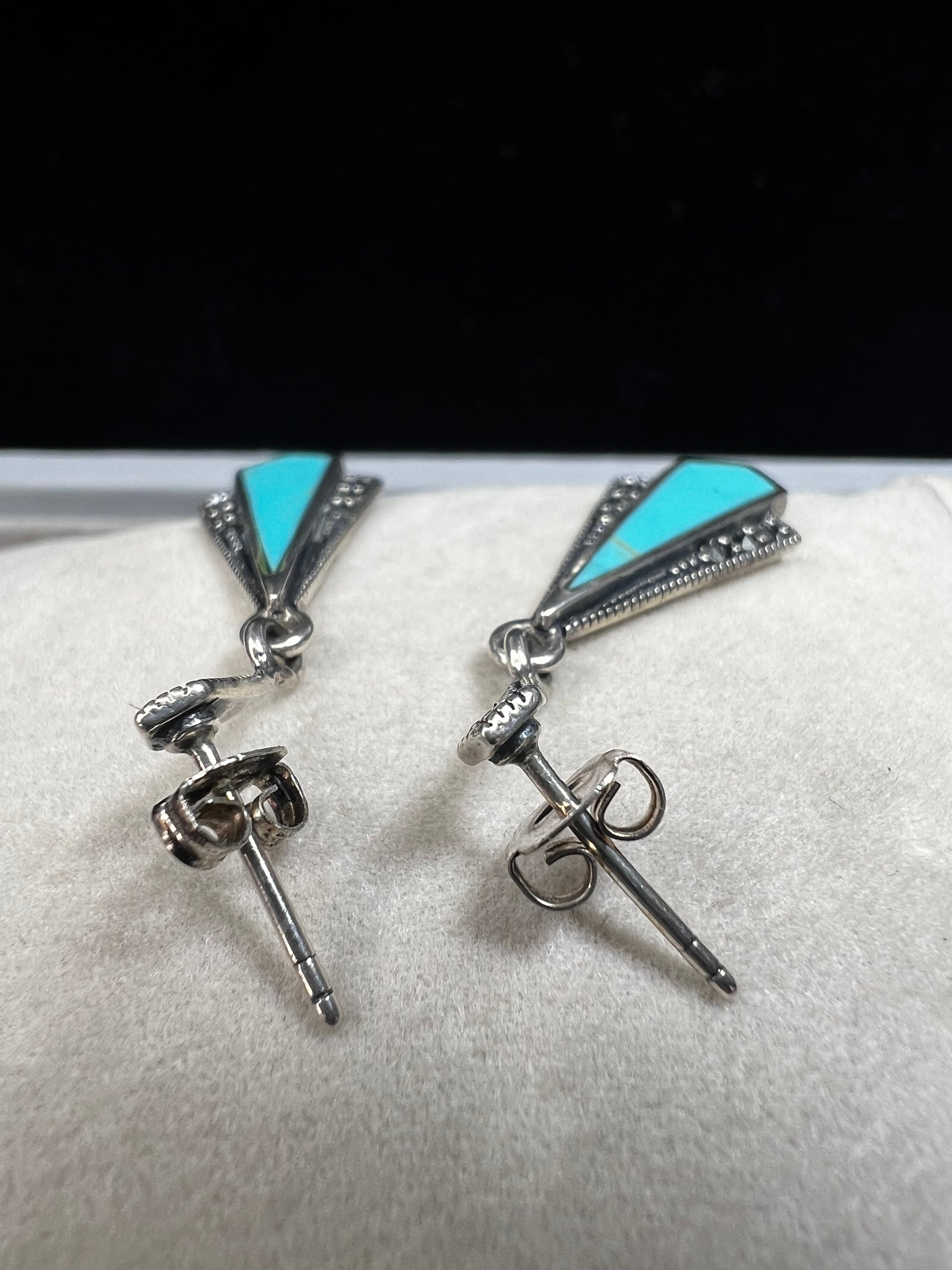 These sterling silver dangle earrings combine the timeless elegance of marcasite with the vibrant appeal of faux turquoise. They are an ideal accessory for adding vintage-inspired sophistication to any outfit.